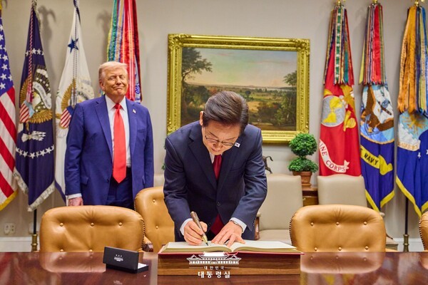 방명록에 사인을 하고 있는 이재명 대통령, 이를 바라보는 트럼프 (사진=대통령실)
